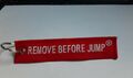 Angebot:Remove Before Jump-Rot /Weiß - Schlüsselanhänger-Schrift gestickt-Neu