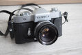 Yashica TL Spiegelreflexkamera mit Yashinon DX 50mm 1:2 Objektiv, Schutzhülle